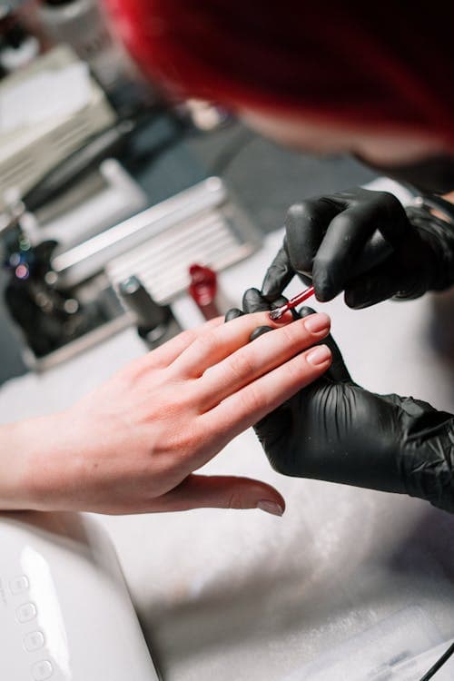 Nail artist applying gel polish in salon